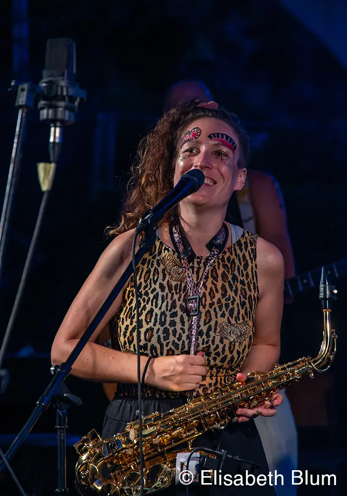 Portrait shot if one of the Zirkusbands singers with her saxophone